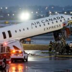Air Canada Express CRJ-900 on Runway 4 at LaGuardia Airport at night with emergency response vehicles, representing the March 2026 runway collision.