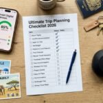 A top-down photograph of a travel planning setup featuring a printed 2026 trip planning checklist with checkmarks and a smartphone displaying a digital version of the same list. The scene includes travel essentials like a passport and headphones, representing an organized preparation process for solo, couple, or family trips.